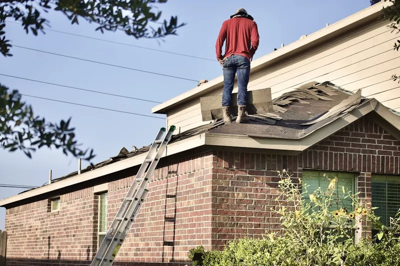 Professional roofer working on a residential roof in Summit Ridge at West Meadows